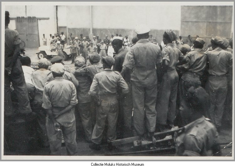 Vertrek van de Kota Inten (1e reis). Langs de militairen op het schip zicht op de uitzwaaiers op de kade.